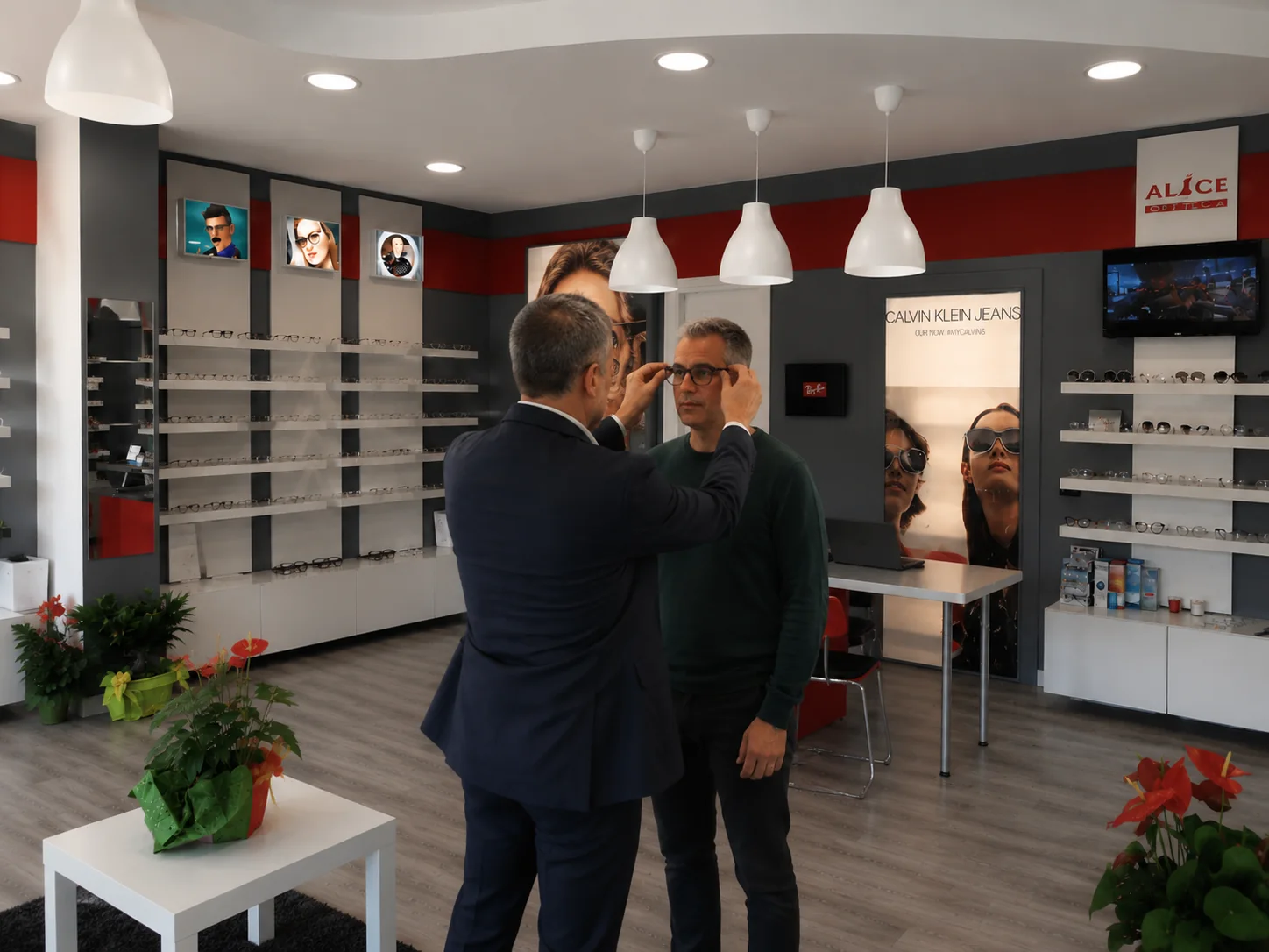 Ottico Alice Optical mentre assiste un cliente nella scelta e regolazione degli occhiali
