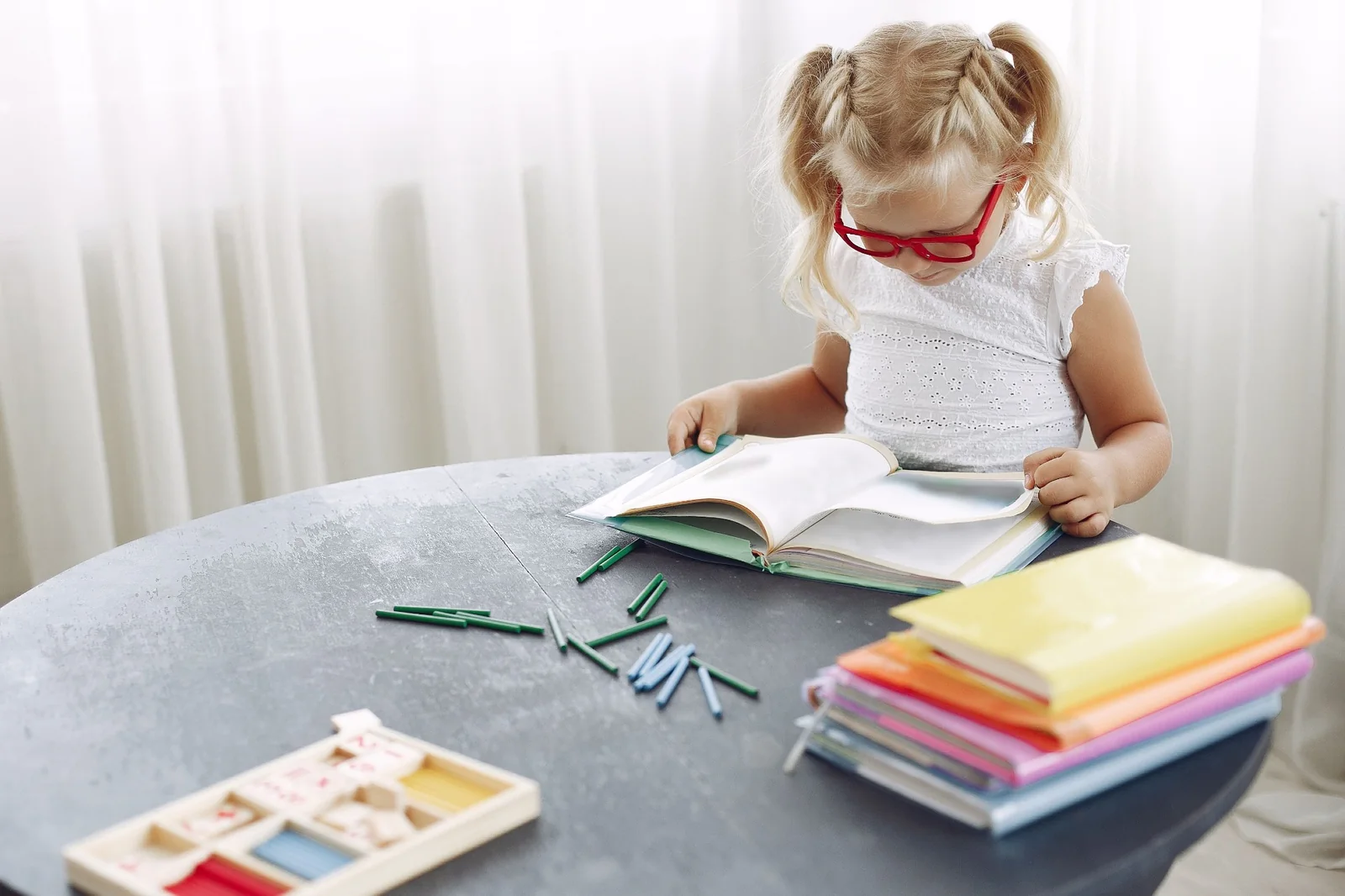 Bambina con occhiali durante un'attività di lettura